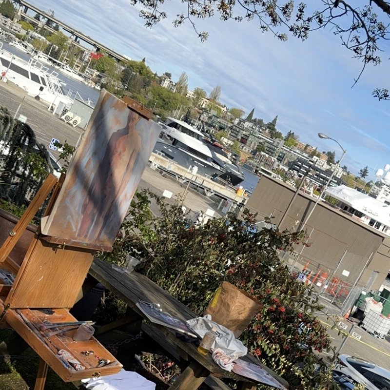 An outdoor painting setup overlooking Seattle's Lake Union, easel with work in progress